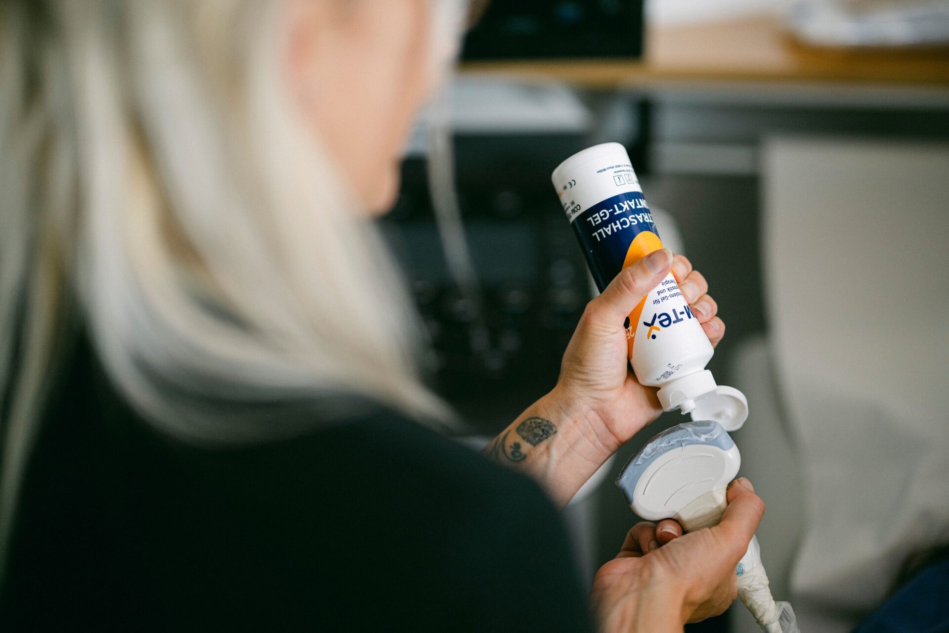 Eine MFA trägt Gel auf ein Gerät zur Ultraschalluntersuchung auf.