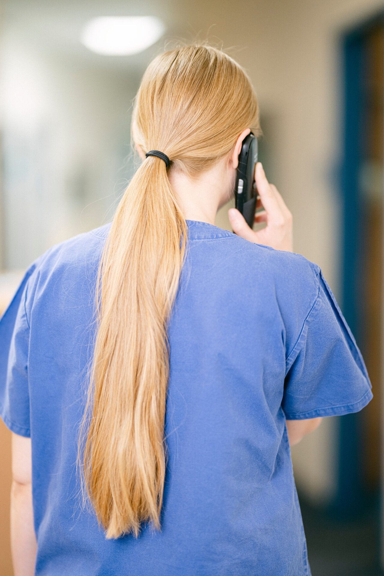 Eine MFA steht mit dem Rücken zur Kamera und telefoniert.